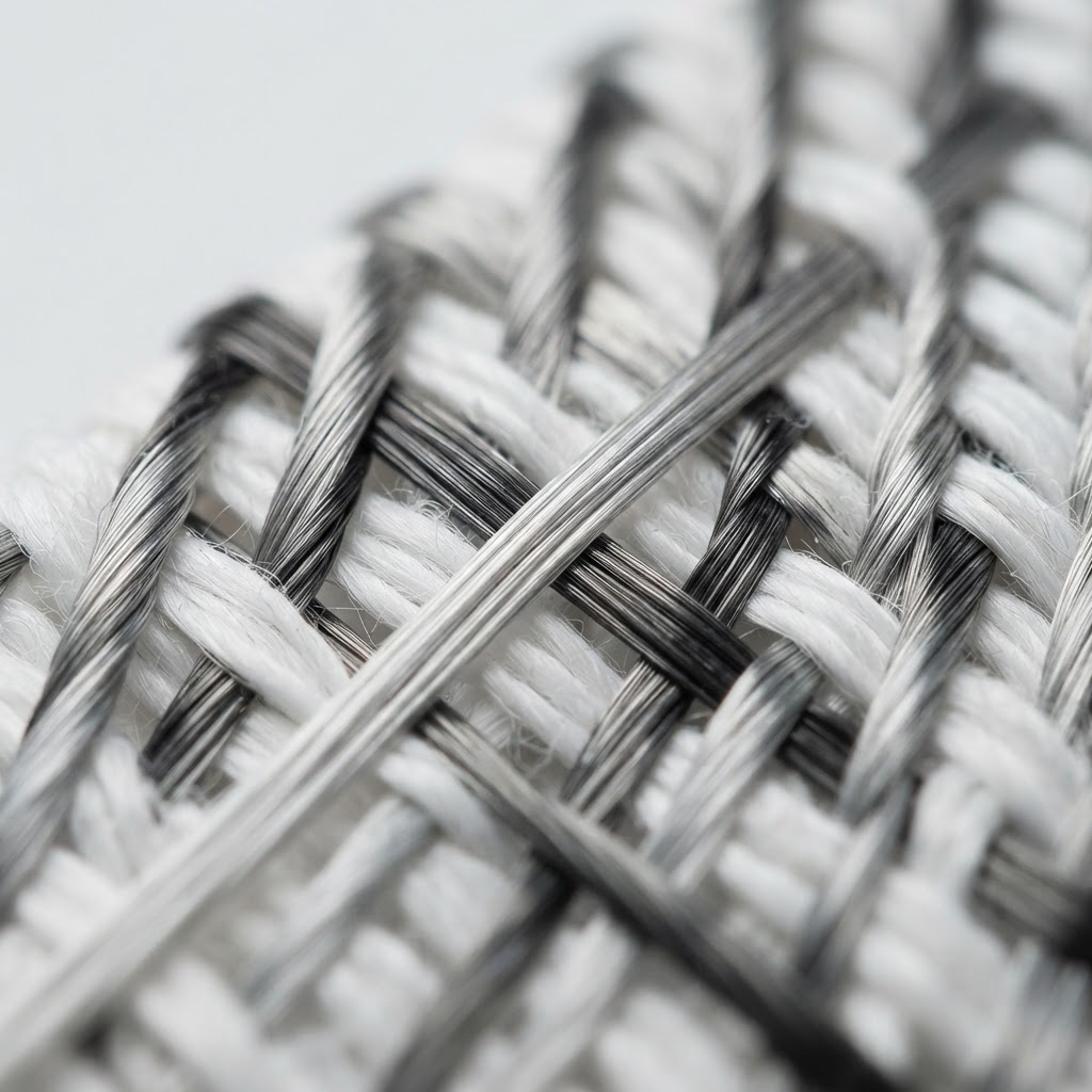 Extreme macro of carbon fibers woven directly into white cotton textile